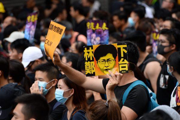 One protester holds up a sign that says "Carrie Lam Step Down" in a march in Mong Kok, Hong Kong, on Aug. 3, 2019. (Song Bilong/The Epoch Times)
