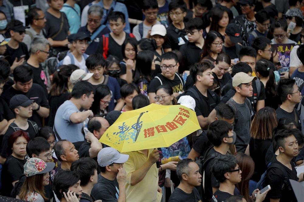 A man carries an umbrella reading "Hold Up Freedom; Oppose Evil Bill" as protesters take part in the anti-extradition bill protests march in Hong Kong, on Aug. 4, 2019. (AP Photo/Vincent Thian)