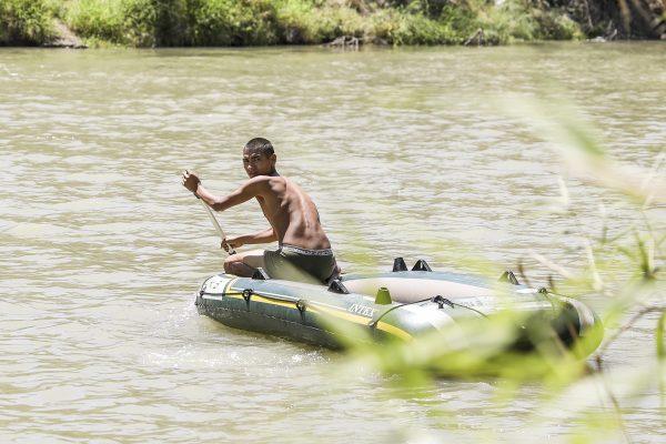 A smuggler paddles his raft back to Mexico after dropping a Guatemalan woman and her daughter on the U.S. side of the Rio Grande near McAllen, Texas, on April 18, 2019. (Charlotte Cuthbertson/The Epoch Times)