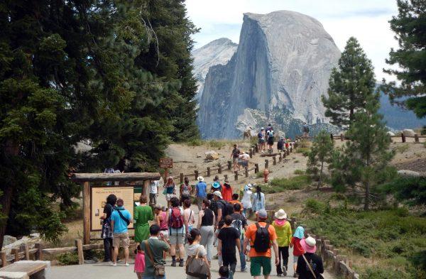 Tourists walk out to Glacier Point with a background view of Half Dome at Yosemite National Park on Aug. 5, 2015. (Frederic Brown/AFP/Getty Images)