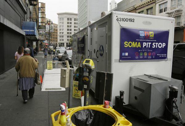 A woman walks past a "Pit Stop" public toilet on Sixth Street, in San Francisco, on Aug. 1, 2019. (Eric Risberg/AP Photo)