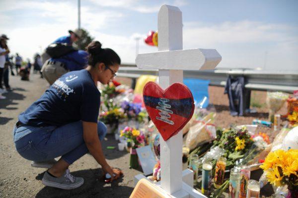 A woman kneels at a makeshift memorial outside Walmart, near the scene of a mass shooting which left at least 22 people dead in El Paso, Texas on Aug. 5, 2019. (Mario Tama/Getty Images)