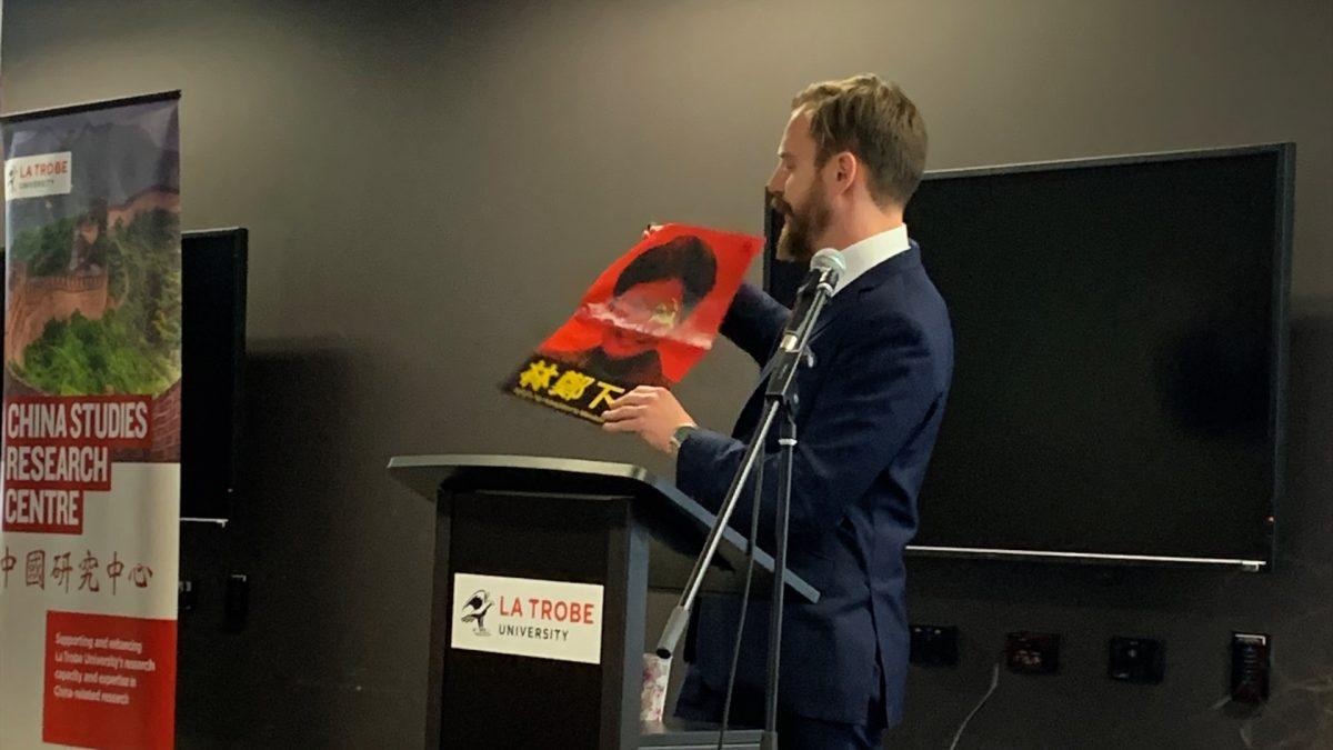 Simon Henderson, an international human rights lawyer, shows attendees some Hong Kong protest paraphernalia at a seminar hosted by La Trobe University's China Studies Research Centre on Aug. 1, 2019, in Melbourne, Australia. (Henry Jom/The Epoch Times)