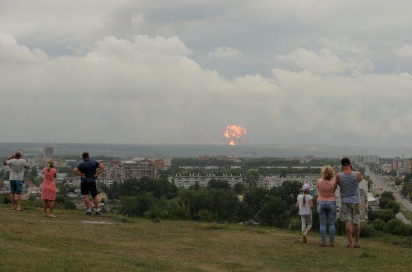 People watch the flame and smoke rising from the site of blasts at an ammunition depot near the town of Achinsk in Krasnoyarsk region, Russia Aug. 5, 2019. (Reuters/Dmitry Dub)