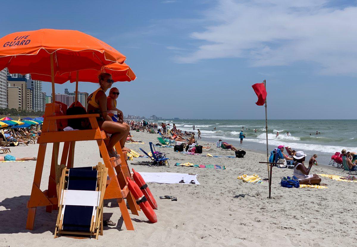 Lifeguards watch people enjoying the beach on a hot summer day in Myrtle Beach, South Carolina on July 27, 2019. Sharks were seen feeding close to shore in August 2019, leading to lifeguards closing the beach for several hours. (Daniel Slim/AFP/Getty Images)