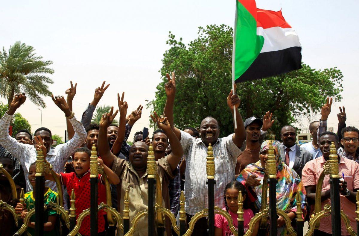 Sudanese people carry their national flag and chant slogans as they celebrate the signing of a constitutional declaration between Deputy Head of Sudanese Transitional Military Council Mohamed Hamdan Dagalo and Sudan's opposition alliance coalition's leader, Ahmad al-Rabiah, outside the Friendship Hall, in Khartoum, Sudan, on Aug. 4, 2019. (Mohamed Nureldin Abdallah/Reuters)