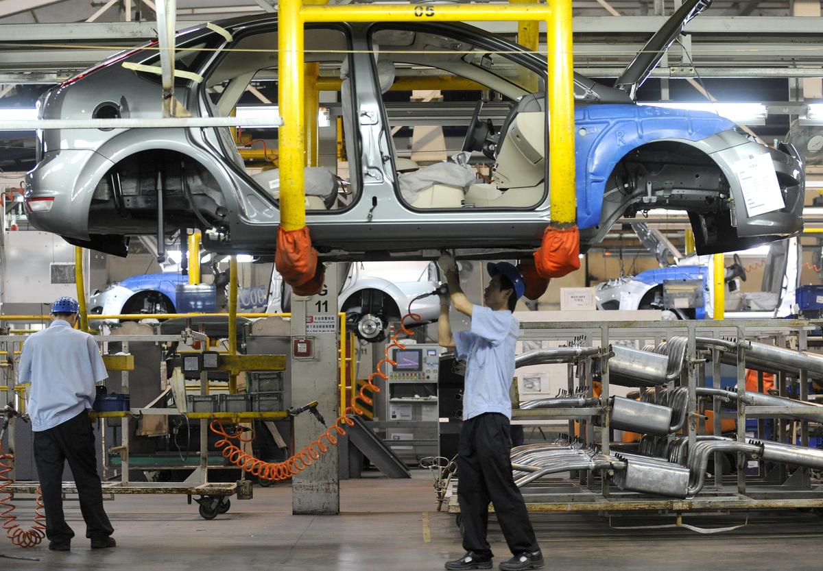 Workers on a vehicle assembly line at the Ford-Changan joint venture plant in Chongqing, China, on June 3, 2011. (Liu Jin/AFP/Getty Images)