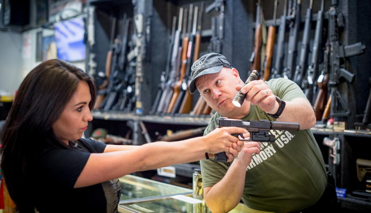 Edward Wilks, owner of Tradesmen Gun Store and Pawnshop helps a customer with a firearm at his store in Rifle, Colorado, on April 24, 2018. (EMILY KASK/AFP/Getty Images)