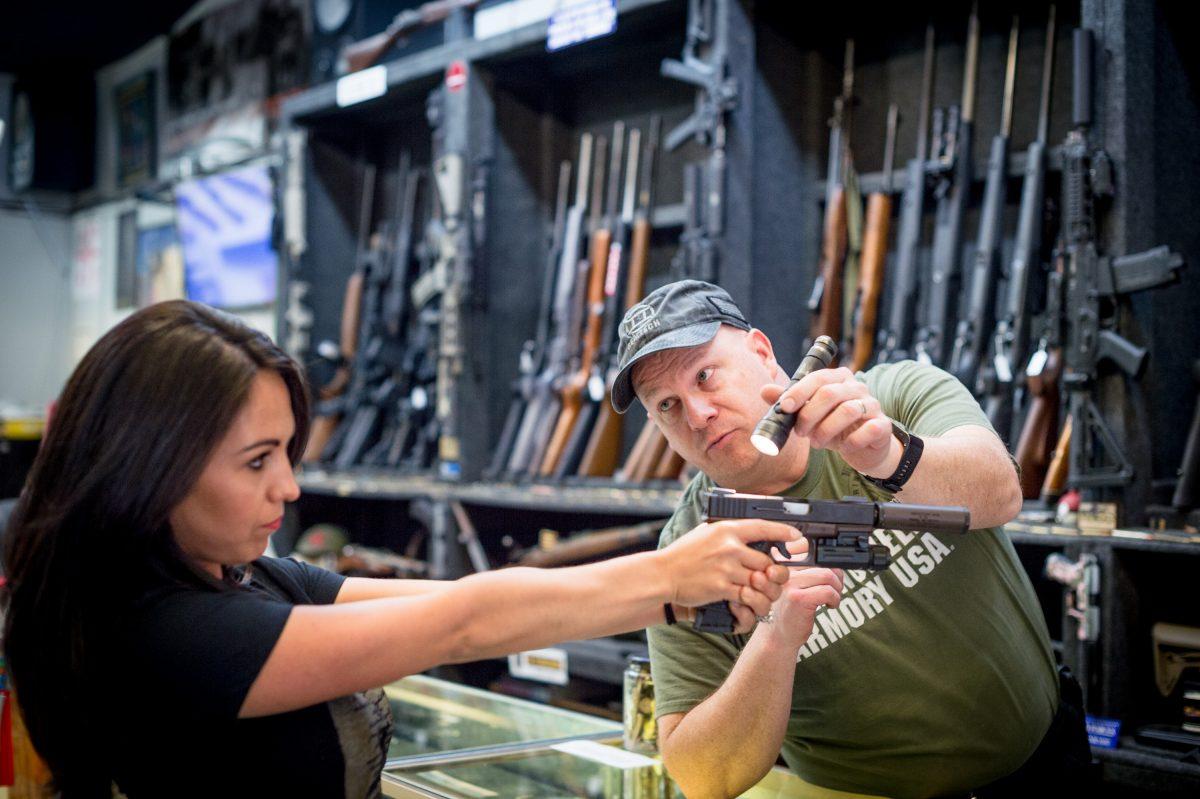 Edward Wilks, owner of Tradesmen Gun Store and Pawnshop helps Lauren Boebert with a firearm at his store in Rifle, Colorado on April 24, 2018. (Emily Kask/AFP/Getty Images)