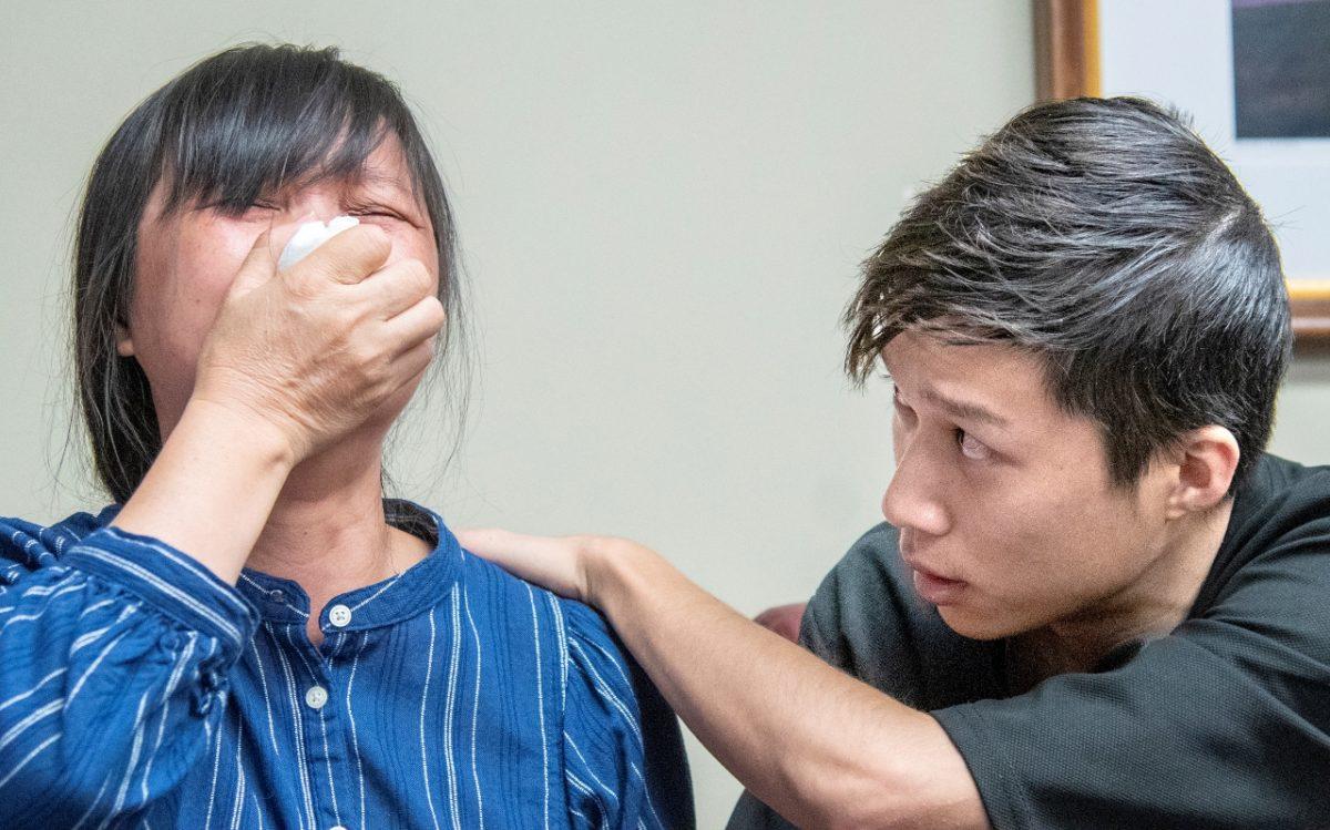 Yingying Zhang's mother, Lifeng Ye (L), is comforted by Yingying's brother Zhengyang Zhang, during a press conference at lawyer Steve Beckett's law office in Urbana, Ill., on Aug. 7, 2019. (Robin Scholz/The News-Gazette via AP )