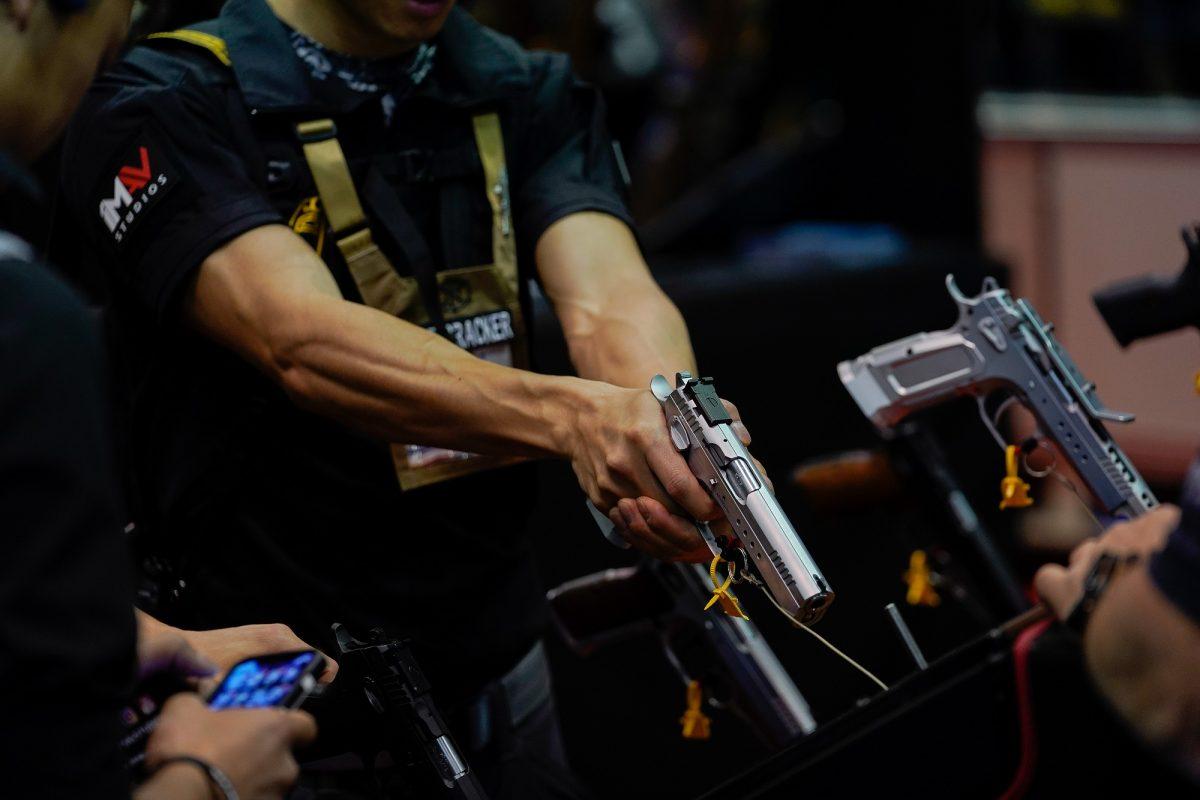 An attendee handles a semiautomatic handgun during the annual National Rifle Association's annual meeting in an April 2019 file photograph. (Bryan Woolston/Reuters)
