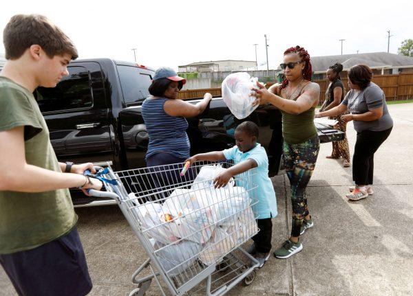 Jesse Van Fleet (L) and others assists in unloading donated items for the pantry at the Carlisle Crisis Center in Forest, Miss., on Aug. 8, 2019. (Rogelio V. Solis/AP Photo)