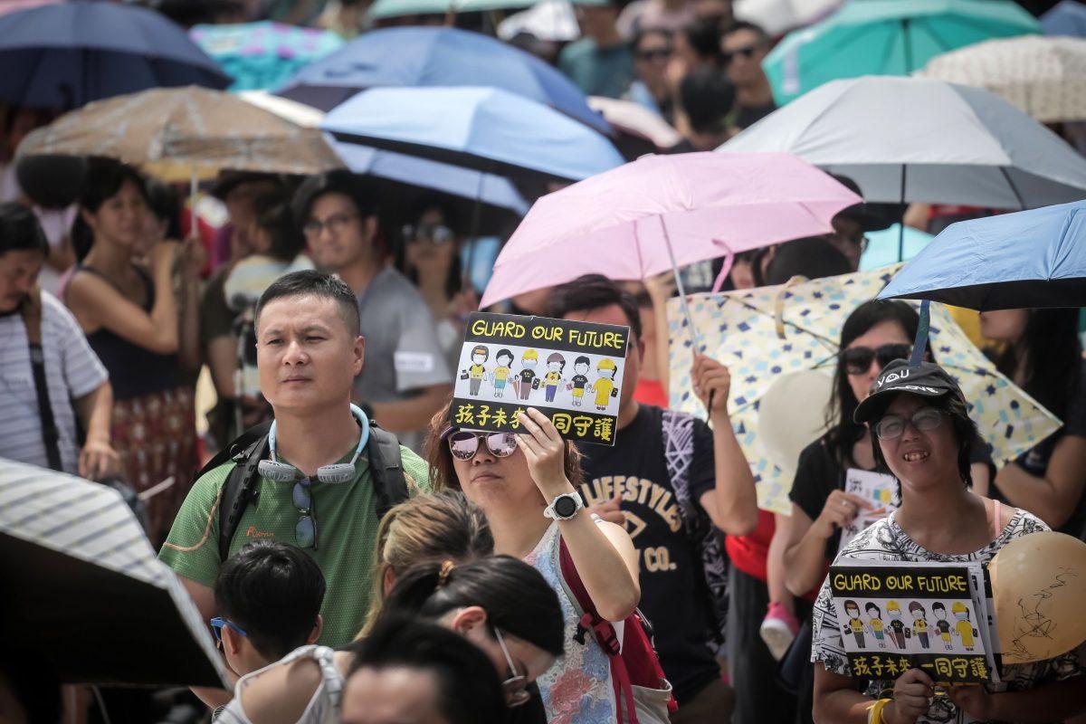 A woman holds a placard made for children during a "guard our children's future" event for families who are against a controversial extradition bill in Hong Kong on Aug. 10, 2019. (Vivek Prakash/AFP/Getty Images)