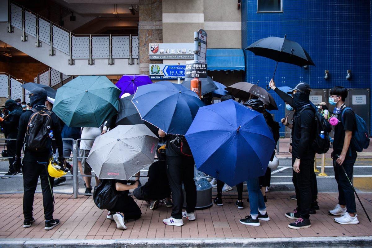 Protesters shelter each other under umbrellas as build barricade in the Tai Wai area during demonstrations against a controversial extradition bill in Hong Kong on Aug. 10, 2019. (Anthony Wallace/AFP/Getty Images)
