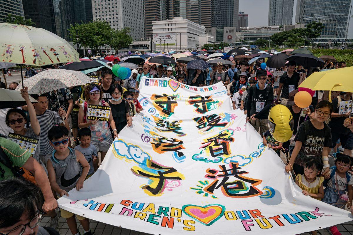 Families hold a banner as they march on a street during a "Guard Our Children's Future" rally for families who are against the controversial extradition bill in Hong Kong, on Aug. 10, 2019. (Anthony Kwan/Getty Images)