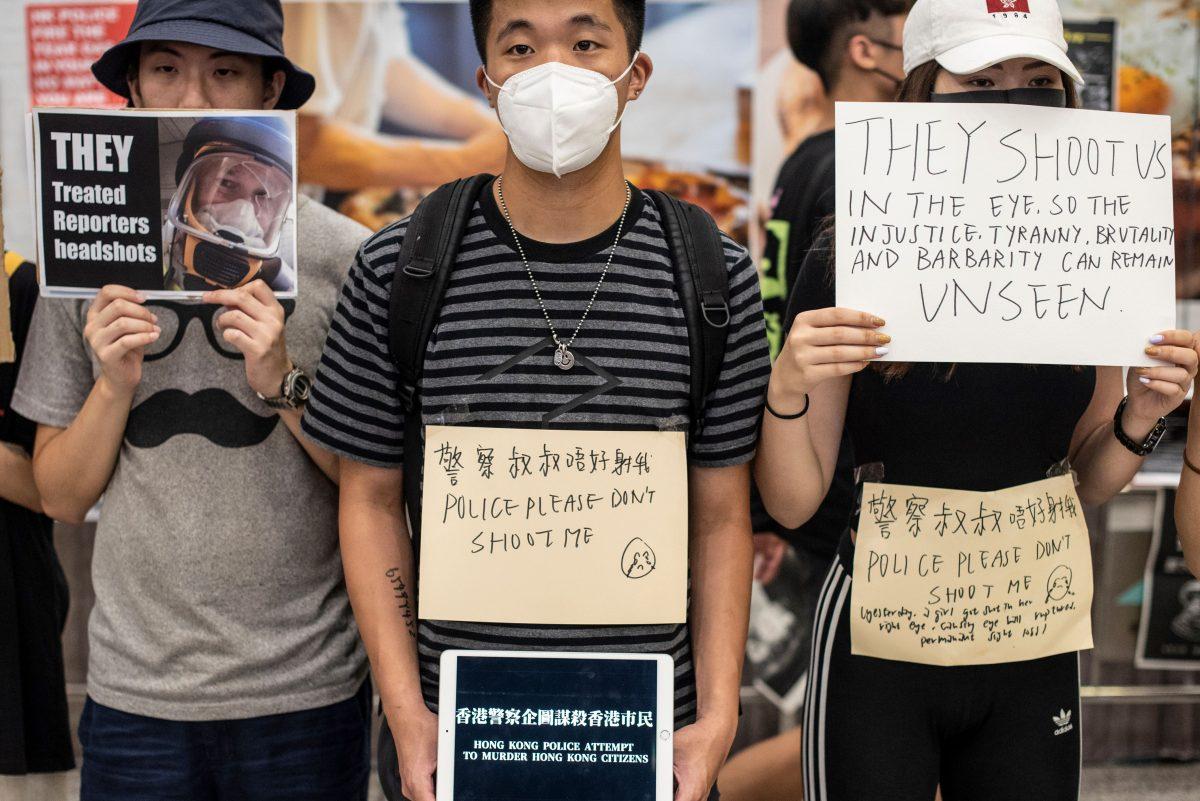 Protesters hold placards at Hong Kong's international airport following a protest against the police brutality and the controversial extradition bill on Aug. 12, 2019. (Philip Fong/AFP/Getty Images)