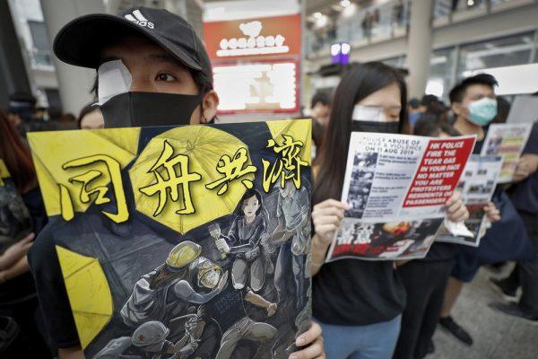 Protesters wear eyepatch during a protest at the arrival hall of the Hong Kong International Airport in Hong Kong, Aug. 12, 2019. (AP Photo/Vincent Thian)