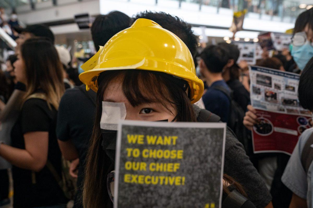 A protester holds a placard as she occupies the arrival hall of the Hong Kong International Airport during a demonstration in Hong Kong, on Aug. 12, 2019. (Anthony Kwan/Getty Images)