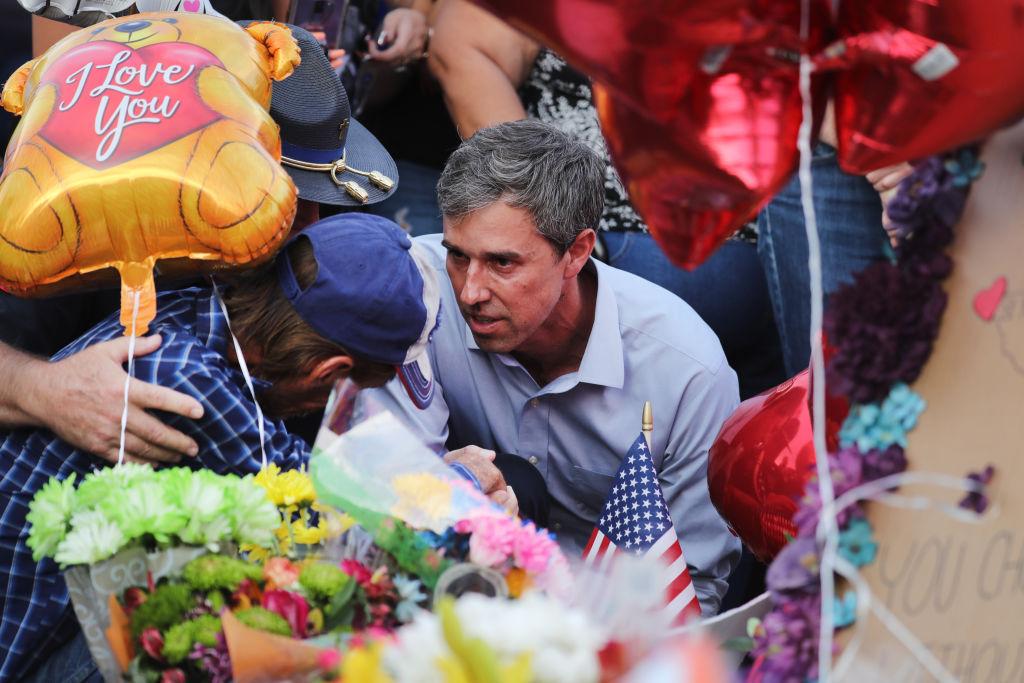 Democratic presidential candidate and former Rep. Beto O’Rourke (D-TX) (C) consoles a man at a makeshift memorial outside Walmart honouring victims of a mass shooting there which left 22 people dead, in El Paso, Texas on Aug. 7, 2019. (Mario Tama/Getty Images)