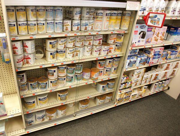Cans of powdered baby formula are seen locked behind glass on shelves at a pharmacy in Chicago in a file photo. (Tim Boyle/Getty Images)