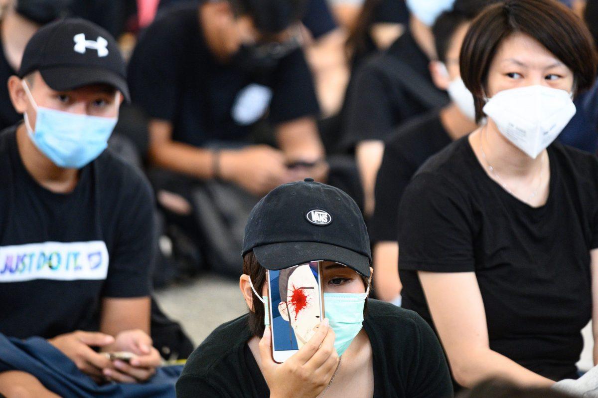 A protester holds a mobile phone showing a picture of a bleeding eye during a protest at Hong Kong's International airport on Aug. 13, 2019. (Philip Fong/AFP/Getty Images)