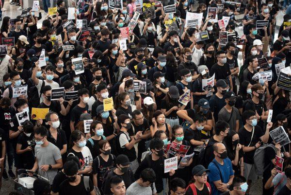 Pro-democracy protesters try to occupy the departures hall during another demonstration at Hong Kong's international airport on Aug. 13, 2019. (Philip Fong/AFP/Getty Images)