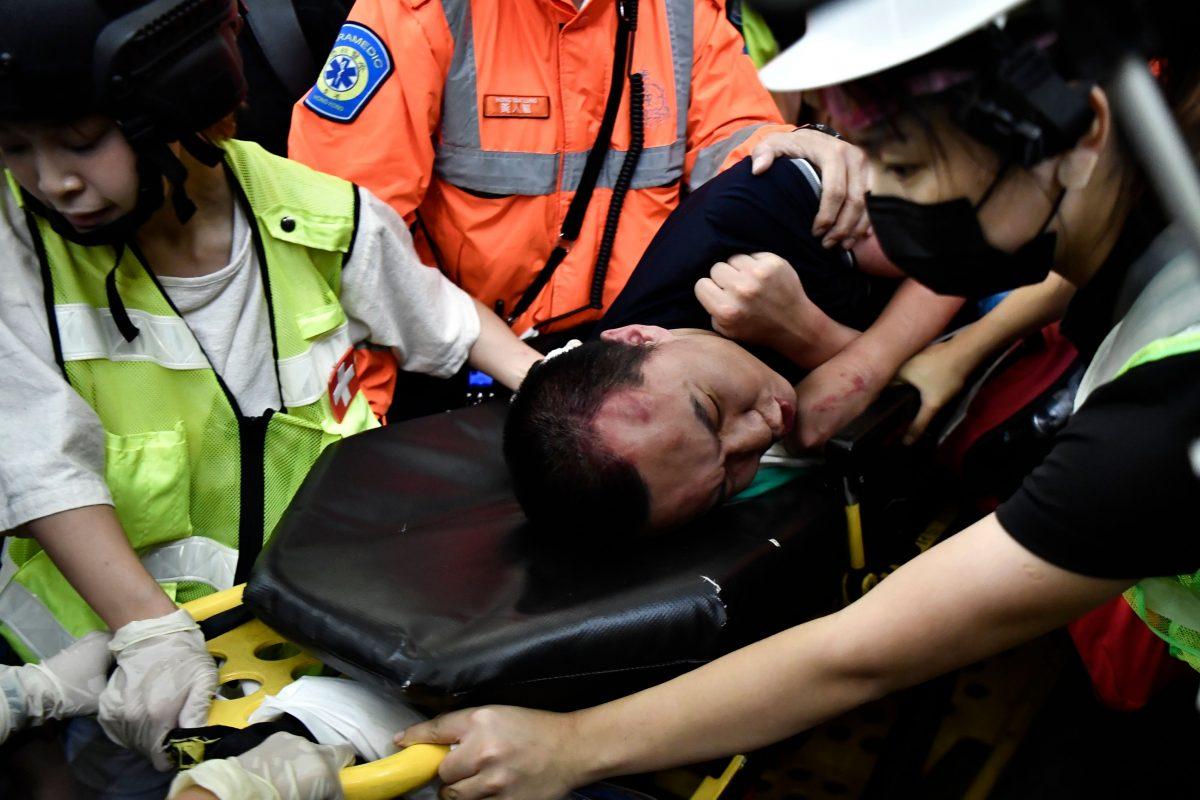 An injured man who was suspected by protestors of being a Chinese spy is taken away by paramedics at Hong Kongs international airport, late on Aug. 13, 2019. (Anthony Wallace/AFP/Getty Images)