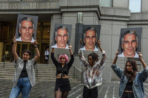 A protest group called “Hot Mess” hold up signs of Jeffrey Epstein in front of the federal courthouse in New York City, on July 8, 2019. (Stephanie Keith/Getty Images)