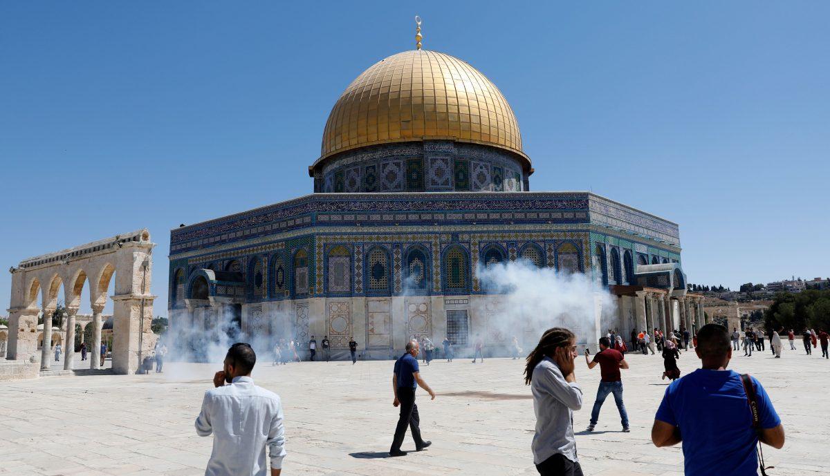 People run for cover from sound grenades fired by Israeli security forces outside the Dome of the Rock mosque, known by Jews as Temple Mount, in Jerusalem's Al-Aqsa Mosque compound on Aug. 11, 2019. Clashes broke out at the site, which both Jews and Muslims consider sacred. (Ahmad Gharabli/AFP/Getty Images)