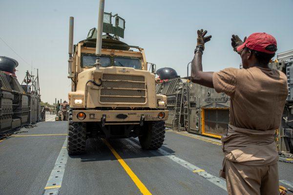 Marines with Lima Company, Battalion Landing Team 3/5, 11th Marine Expeditionary Unit (MEU) drive a 7-ton truck onto a landing craft, air cushion at Kuwait Naval Base, Kuwait City, Kuwait, in this undated handout picture released by U.S. Navy on August 7, 2019. (Jared Sabins/U.S. Army/Handout via Reuters)