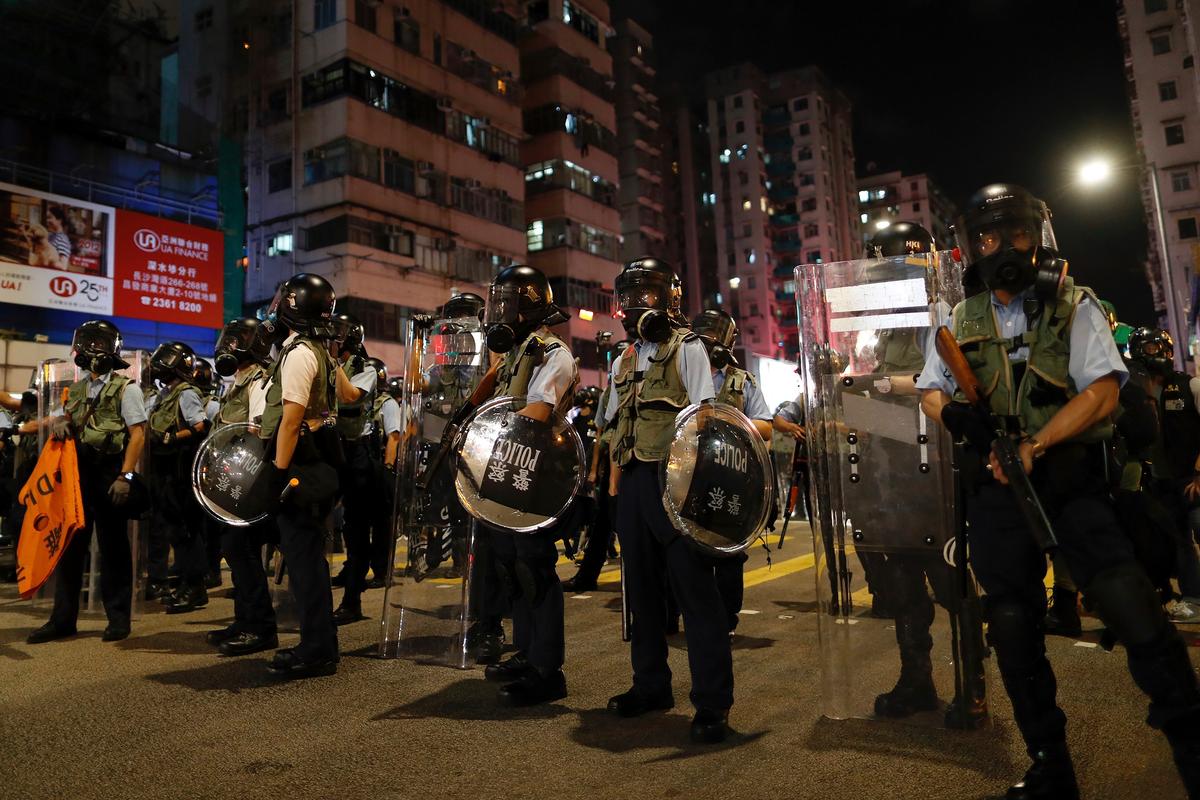 Policemen in riot gear stand on a street as they confront protesters in Hong Kong on Aug. 14, 2019. German Chancellor Angela Merkel is calling for a peaceful solution to the unrest in Hong Kong amid fears China could use force to quell pro-democracy protests. (Vincent Yu/AP)