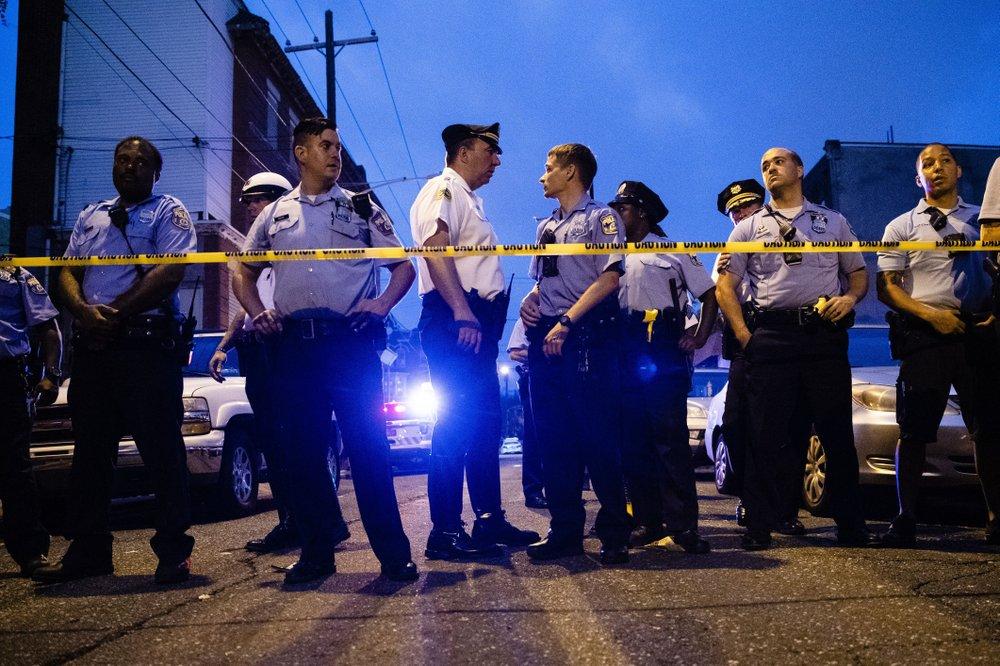 Officers gather for crowd control near a massive police presence set up outside a house as they investigate a shooting on Aug. 14, 2019 in Pa. (Matt Rourke/AP)