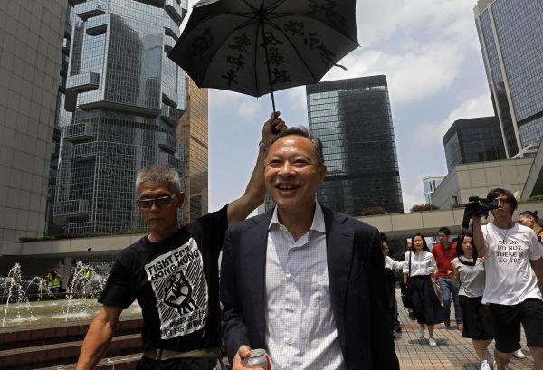 Occupy Central leader Benny Tai, center, is accompanied by a supporter who raises an umbrella as he leaves High Court in Hong Kong on Aug. 15, 2019. (Vincent Yu/AP)