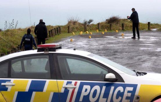 Police collect and photograph evidence in the carpark of the Te Toto Gorge lookout on Whaanga Rd, south of Raglan, New Zealand, Aug. 16, 2019. (AP, Alan Gibson/New Zealand Herald/The Canadian Press)