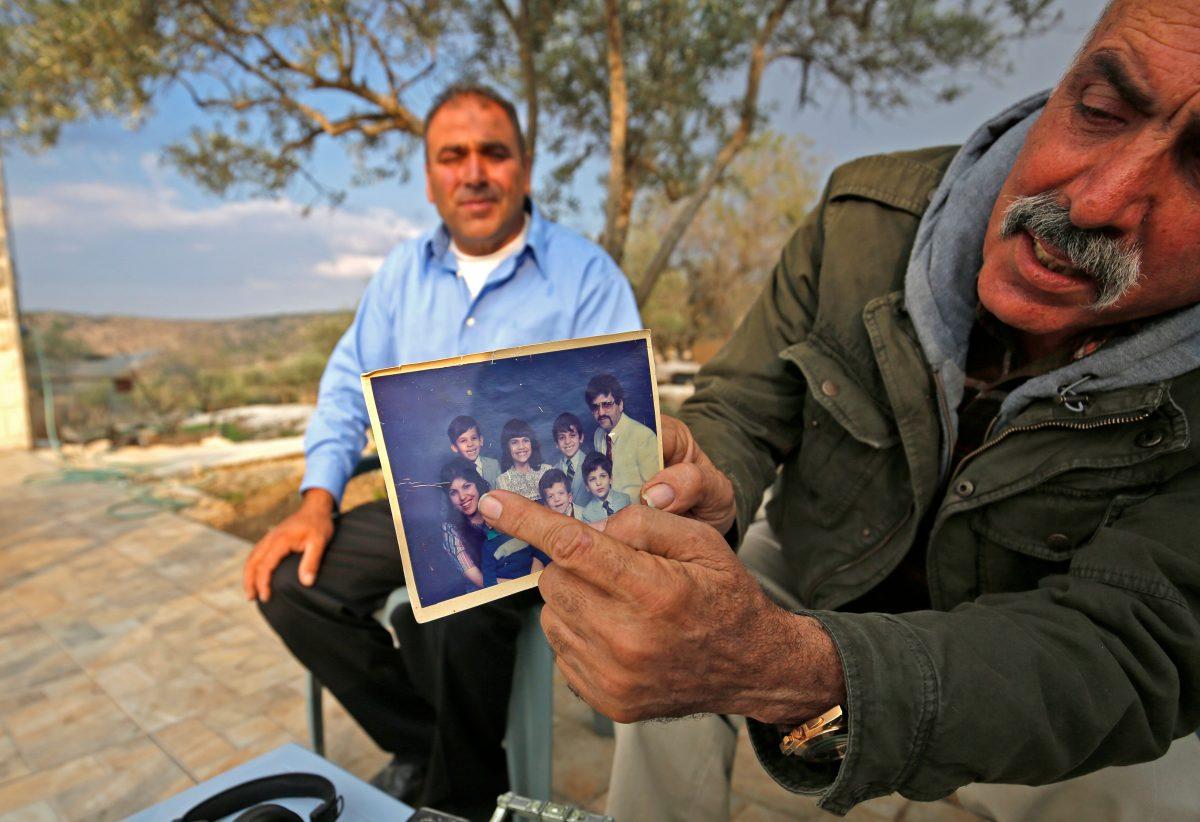 The uncle of Rashida Tlaib, right, points to a picture of her in Beit Ur al Foqa in the West Bank on Nov. 8, 2018. (Abbas Momani/AFP/Getty Images)