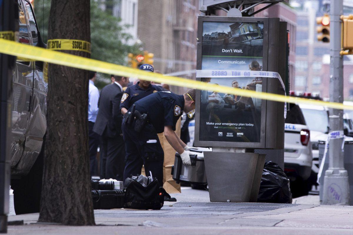 An investigator picks up a suspicious package that was thought to be an explosive device in Manhattan's Chelsea neighborhood in New York on Aug. 16, 2019. (Kevin Hagen/AP Photo).
