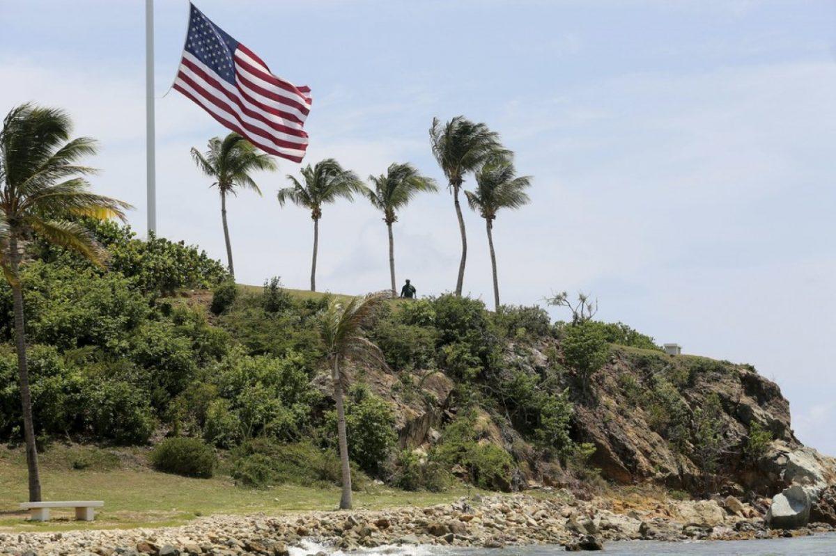 A man stands near a U.S. flag at half staff on Little St. James Island, in the U.S. Virgin Islands, a property owned by Jeffrey Epstein on Aug. 14, 2019. (Gabriel Lopez Albarran/AP Photo)