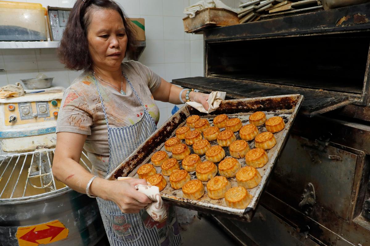 A staff member holds a tray of mooncakes with Chinese words "Hong Kong people" at Wah Yee Tang bakery in Hong Kong on Aug. 9, 2019. (Kin Cheung/AP)