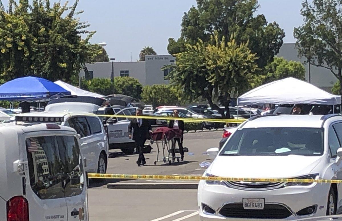 Orange County coroners remove a body of a stabbing victim from a parking lot from a parking lot at California State University, Fullerton on Aug. 19, 2019. (AP Photo/Amy Taxin)