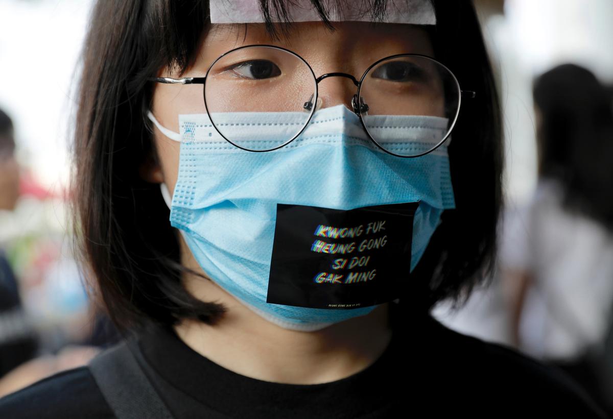 A woman wears a face mask and a sticker reading "Add oil Hong Kong people" during a demonstration at Edinburgh Place in Hong Kong on Aug. 22, 2019. (Vincent Yu/AP)