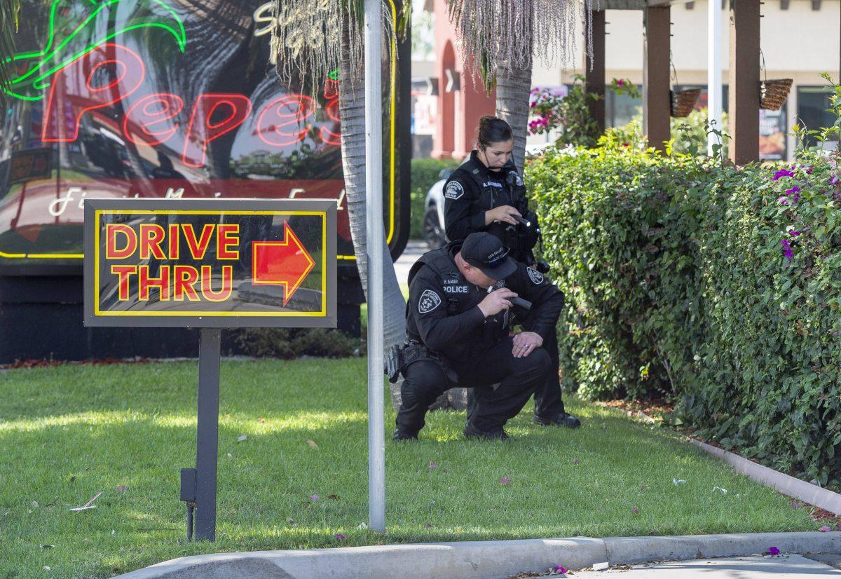 Police investigate after a retired Cal State Fullerton administrator was stabbed to death in Fullerton, Calif. on August 19, 2019. (Paul Bersebach/The Orange County Register via AP)