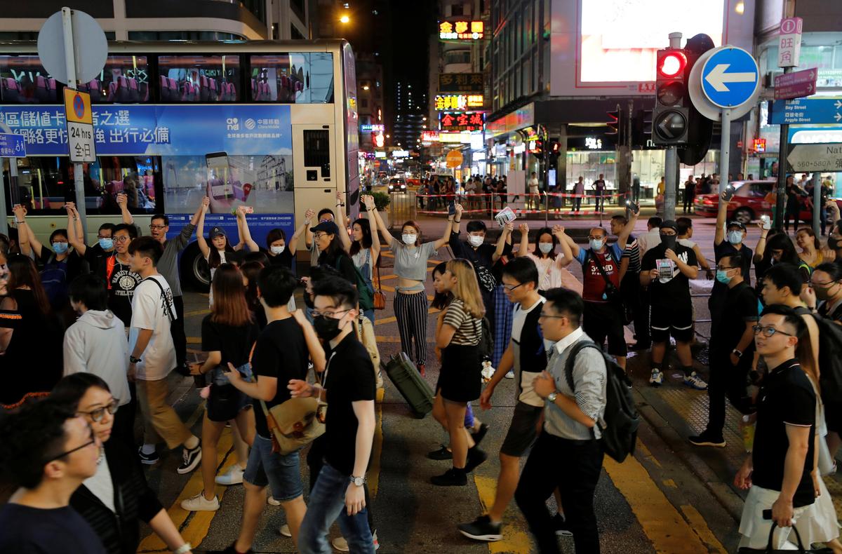 Protesters hold hands to form a human chain during a rally to call for political reforms at Mongkok district in Hong Kong on Aug. 23, 2019. (Tyrone Siu/Reuters)