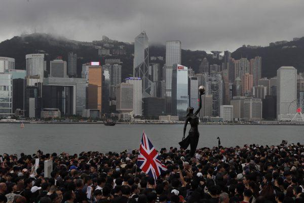 Thousands of protesters, some carrying the British flag, march near the harbor in Hong Kong on July 7, 2019. Hong Kong police confirmed it had received a report on Aug. 9 about a British foreign ministry employee who has been missing since crossing into China on a business trip. (Kin Cheung/AP Photo)