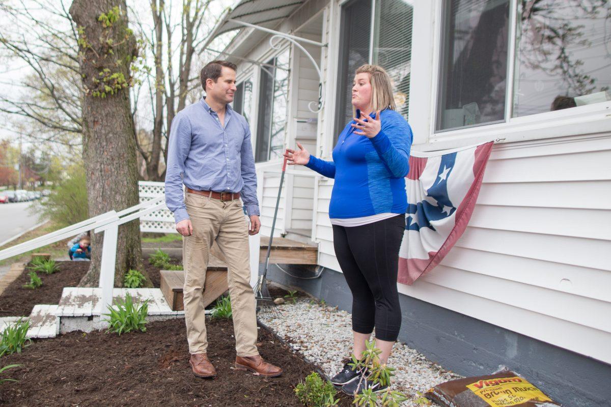 Democratic presidential candidate Rep. Seth Moulton (D-Mass.) speaks with a woman while taking a break from spreading mulch and removing weeds at the Liberty House during a campaign stop in Manchester, New Hampshire on April 23, 2019. (Scott Eisen/Getty Images)