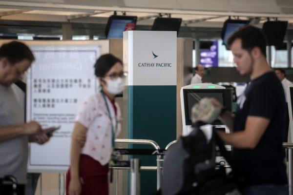 A staff member helps passengers in the Cathay Pacific Airways check-in area at Hong Kong's International Airport on August 10, 2019. (VIVEK PRAKASH/AFP/Getty Images)