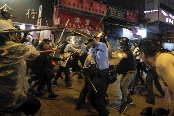 Policemen clash with demonstrators on a street during a protest in Hong Kong, on Aug. 25, 2019. (AP Photo/Kin Cheung)