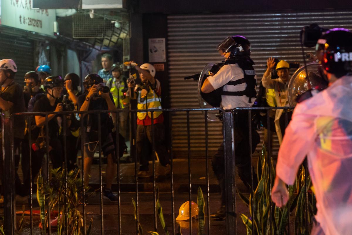 Police officers point their guns towards anti-extradition bill protesters and some reporters after a clash in Tsuen Wan in Hong Kong, on Aug. 25, 2019. (Billy H.C. Kwok/Getty Images)