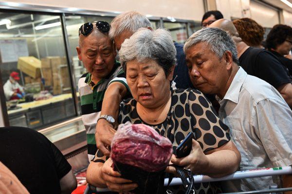 Customer picking up meat from Costco in Shanghai, China on Aug. 27, 2019. (Hector Retamal/AFP/Getty Images)