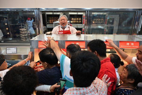 People try to get a roast chicken at the first Costco outlet during the store's opening day in Shanghai, China on Aug. 27, 2019. (Hector Retamal/AFP/Getty Images)