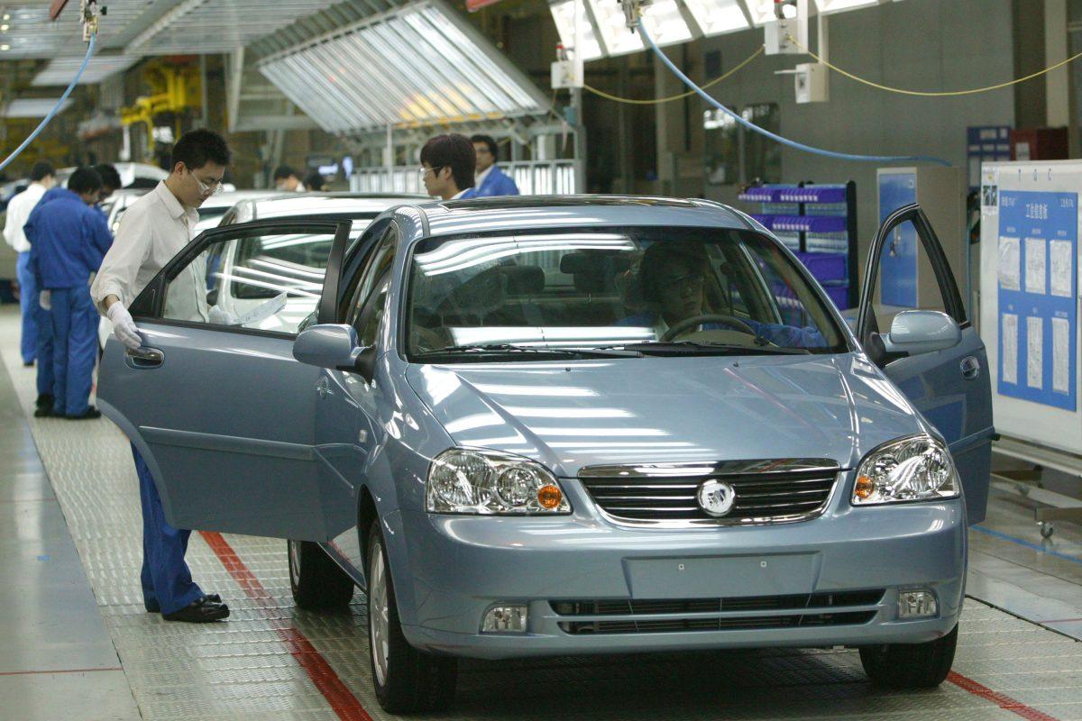 Workers work at a product line of Buick Excelles at Jinqiao South Vehicle Plant of Shanghai General Motors Corp. on May 28, 2005. (China Photos/Getty Images)